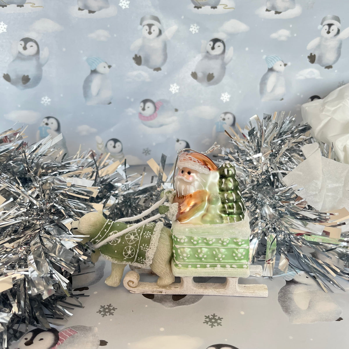 festive tabletop ornament features Santa riding a sleigh