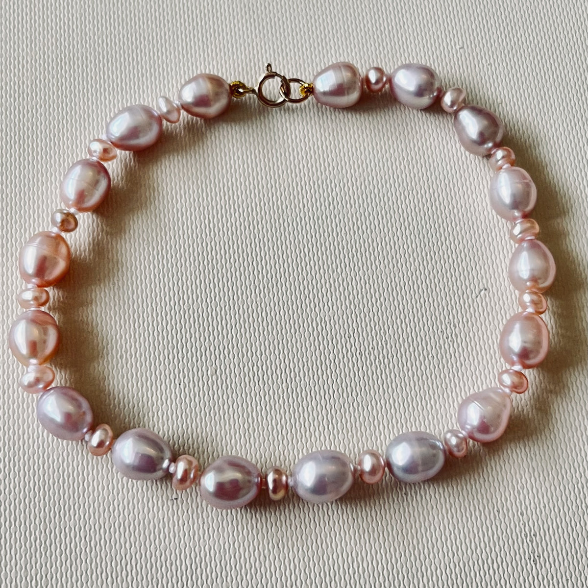 Stunning Pink Cultured Freshwater Pearl Bracelet with a delicate 9ct gold clasps securing it perfectly. Hallmarked 375 on the clasp presented in a beautiful wooden box