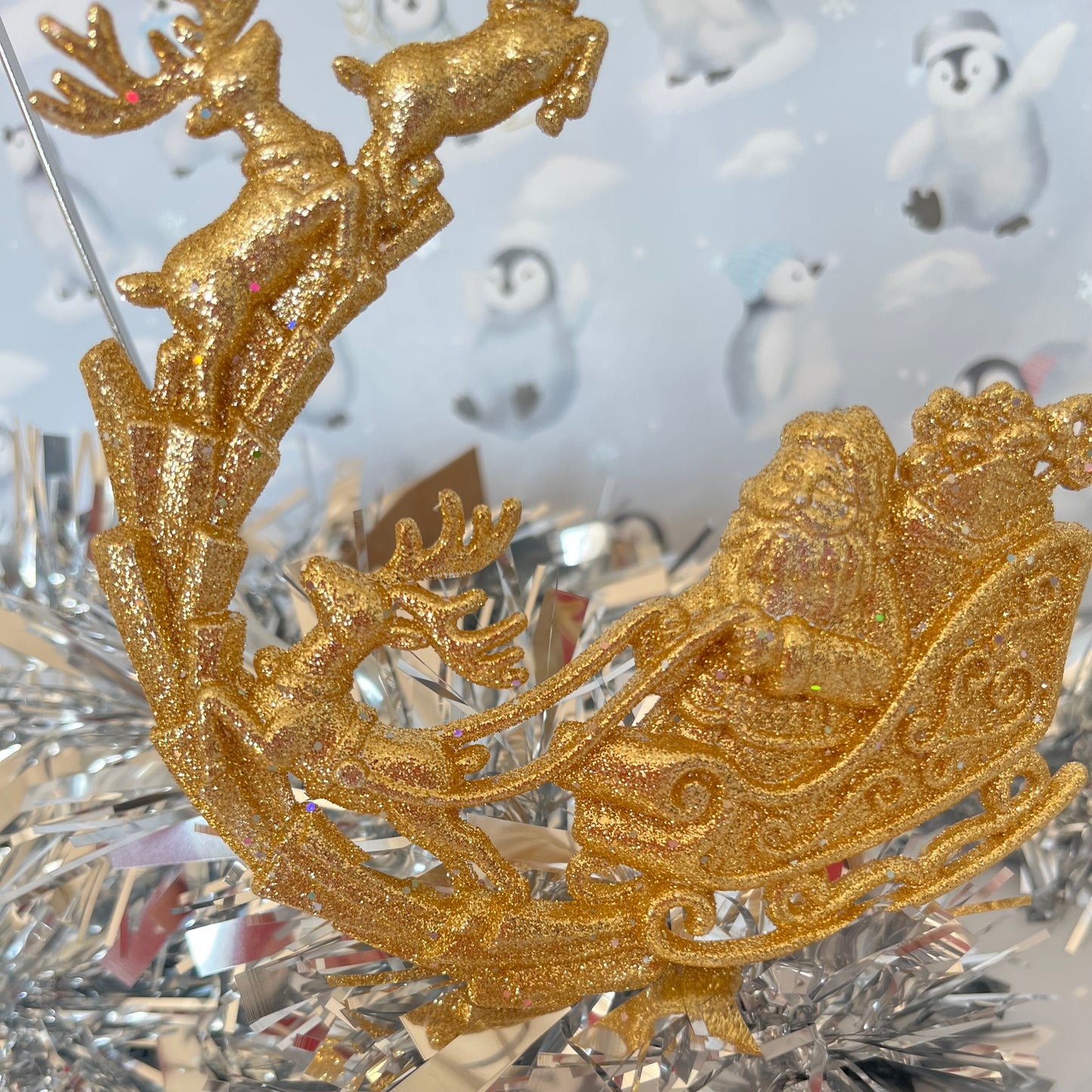 Sparkling, glitter-dusted gold reindeer and Santa sleigh hanging Christmas tree decoration.