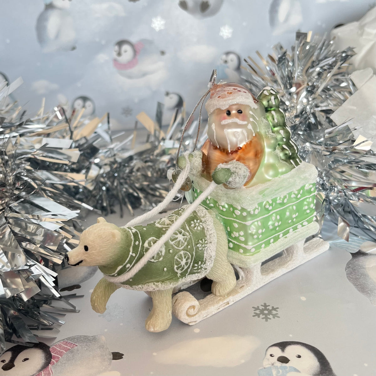 festive tabletop ornament features Santa riding a sleigh