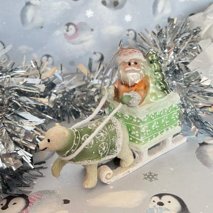 festive tabletop ornament features Santa riding a sleigh