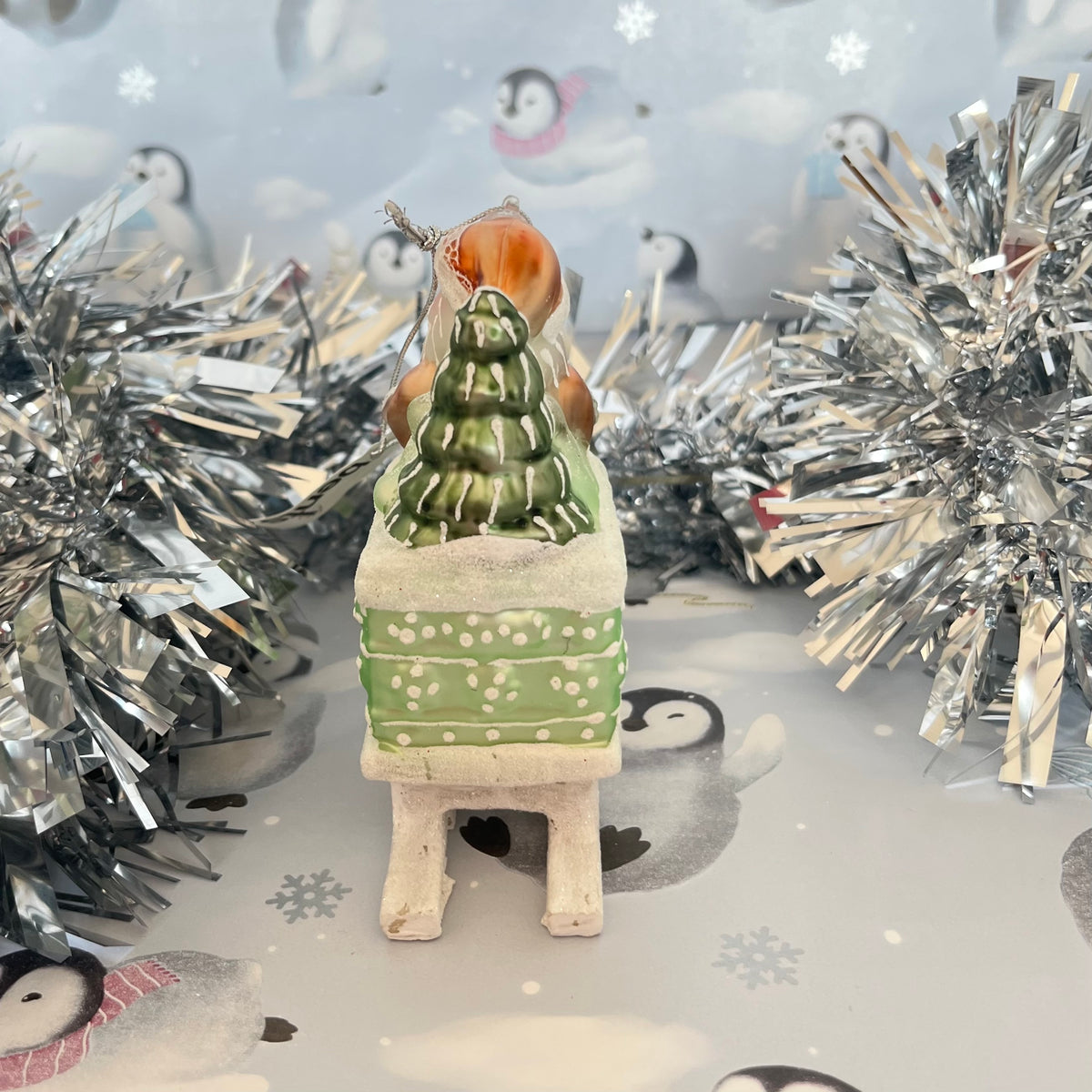 festive tabletop ornament features Santa riding a sleigh