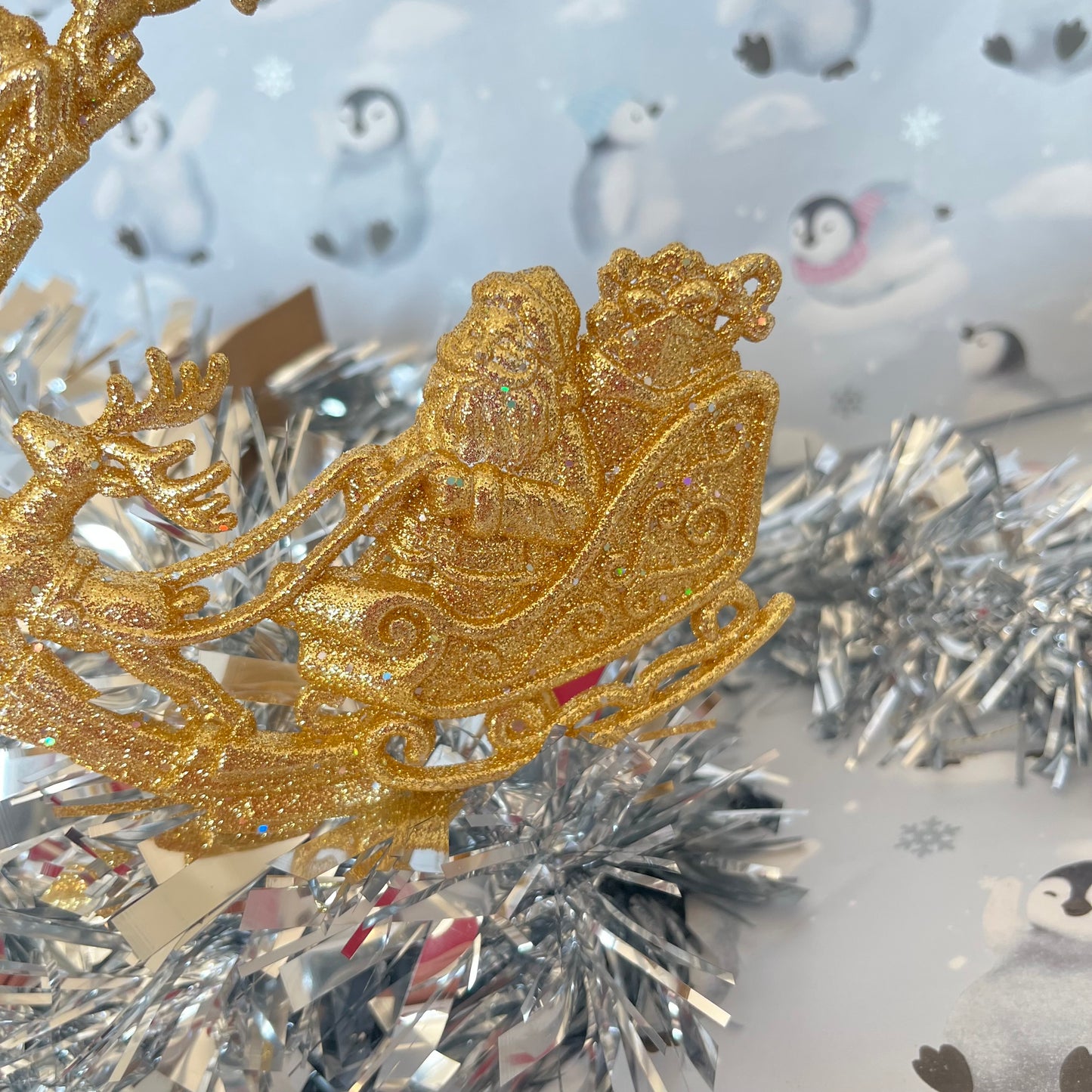 Sparkling, glitter-dusted gold reindeer and Santa sleigh hanging Christmas tree decoration.