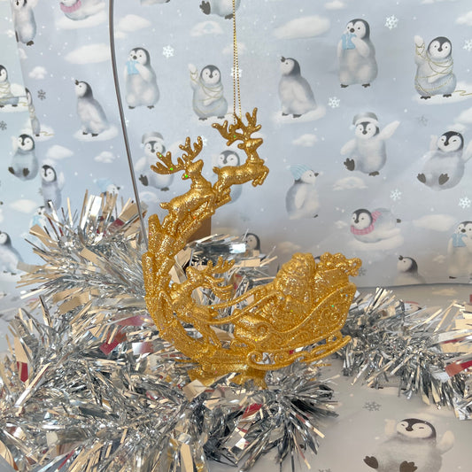 Sparkling, glitter-dusted gold reindeer and Santa sleigh hanging Christmas tree decoration.