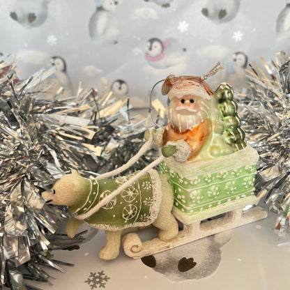 festive tabletop ornament features Santa riding a sleigh