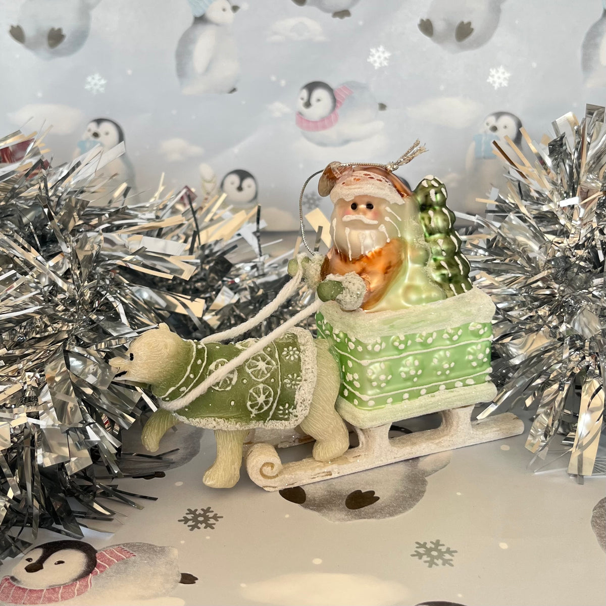 festive tabletop ornament features Santa riding a sleigh