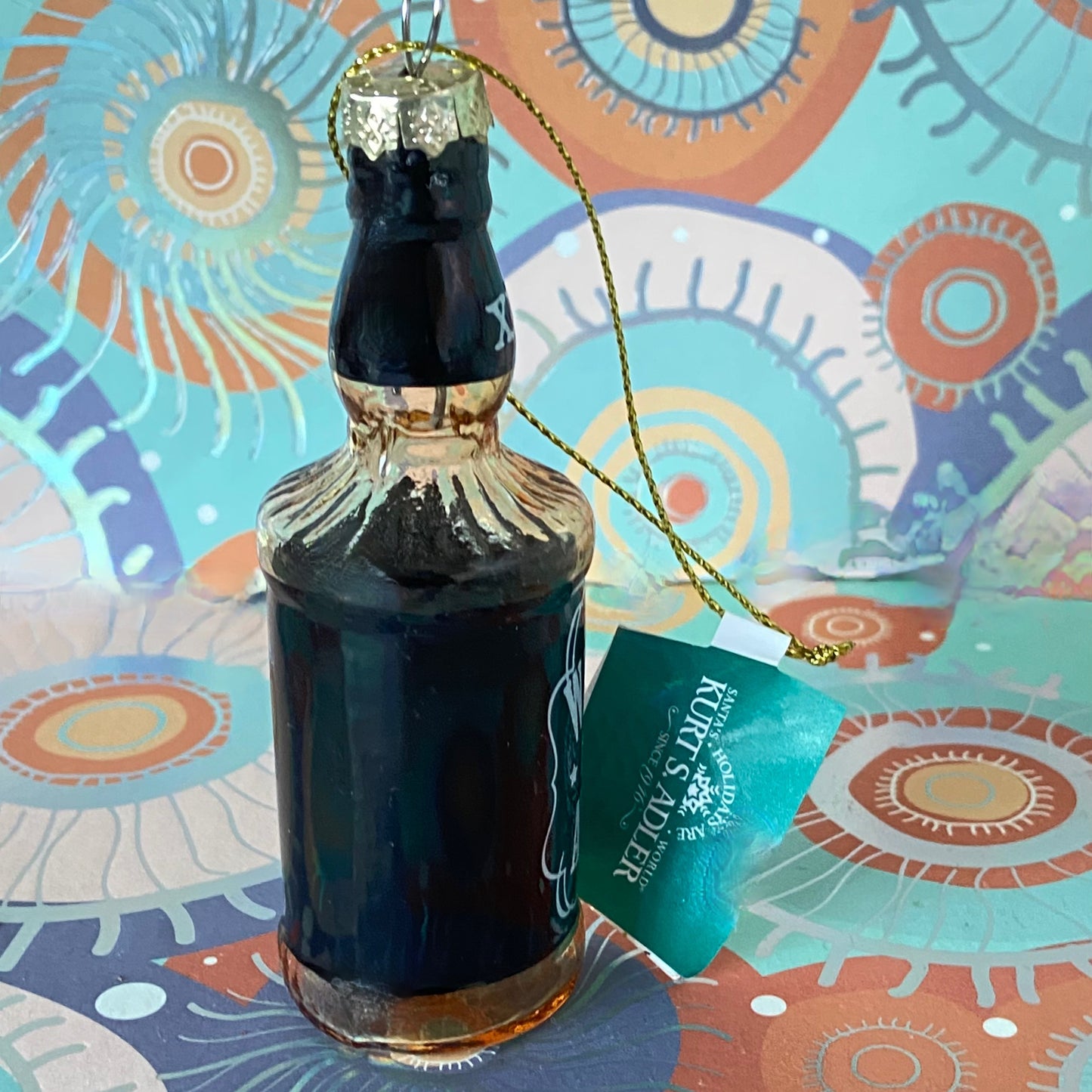 The item is a glass "Whiskey me AWAY" Christmas ornament, often manufactured by brands like Cody Foster & Co. or Kurt Adler.