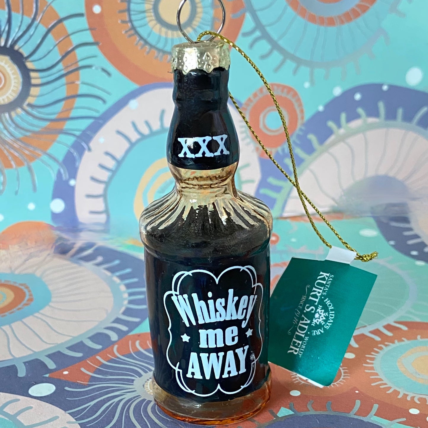 The item is a glass "Whiskey me AWAY" Christmas ornament, often manufactured by brands like Cody Foster & Co. or Kurt Adler.