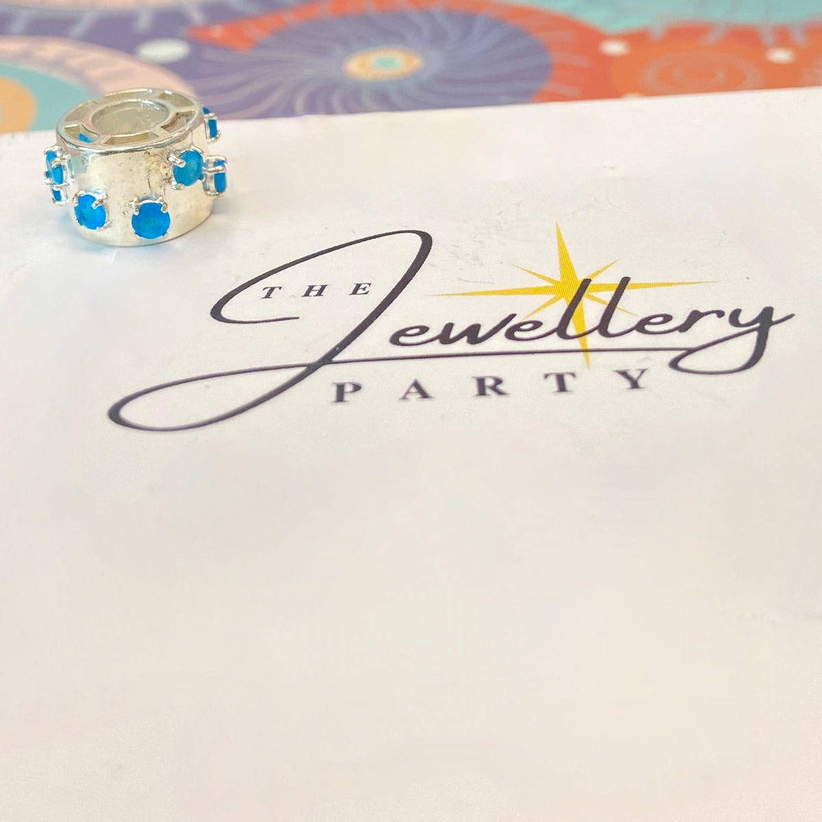 925 sterling silver charm with blue gemstones, featuring the hallmark maker's mark TGGC.