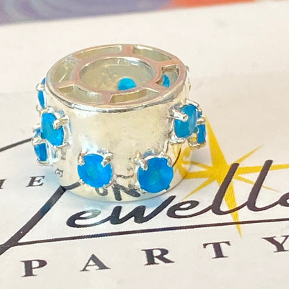 925 sterling silver charm with blue gemstones, featuring the hallmark maker's mark TGGC.