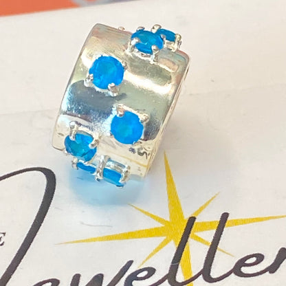 925 sterling silver charm with blue gemstones, featuring the hallmark maker's mark TGGC.