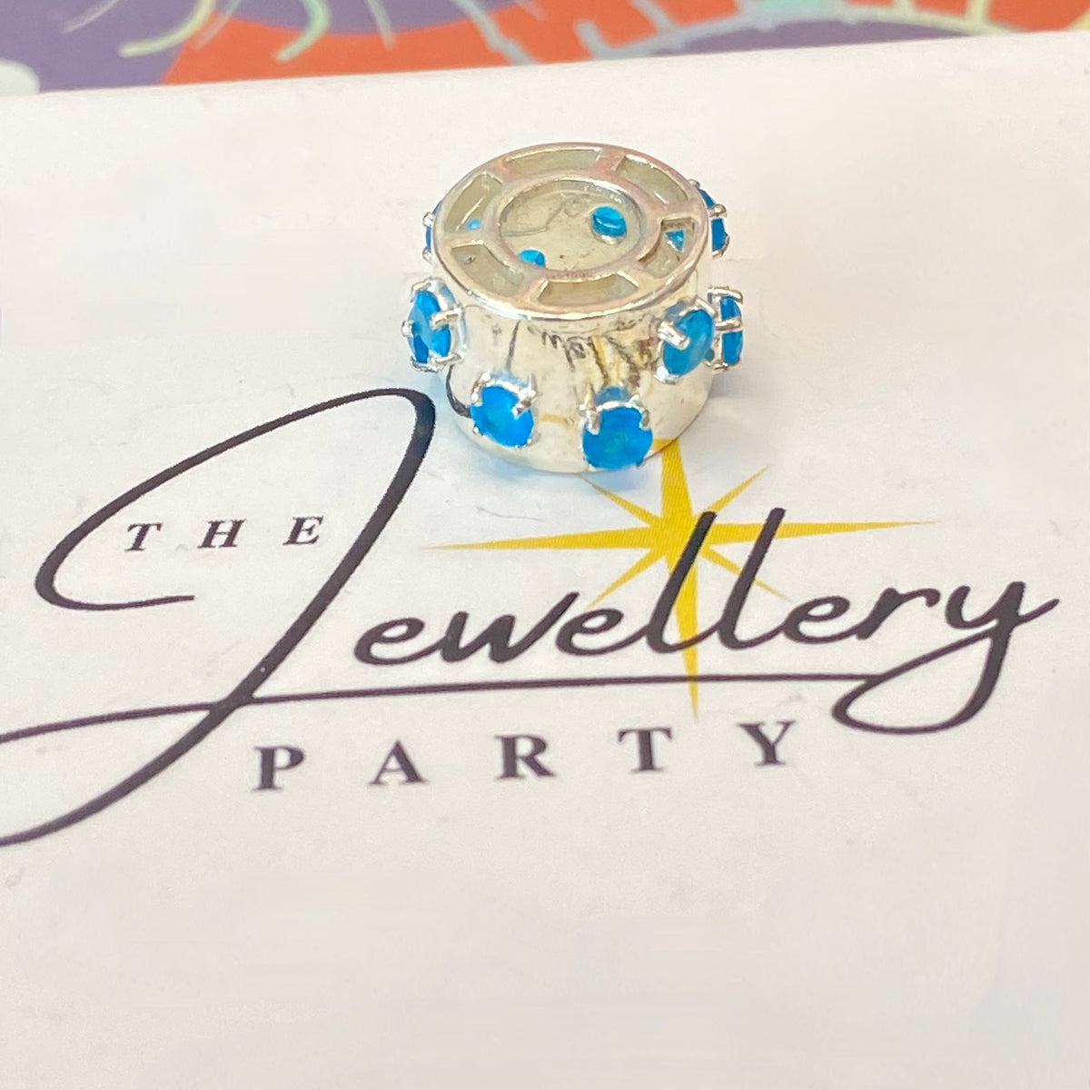 925 sterling silver charm with blue gemstones, featuring the hallmark maker's mark TGGC.