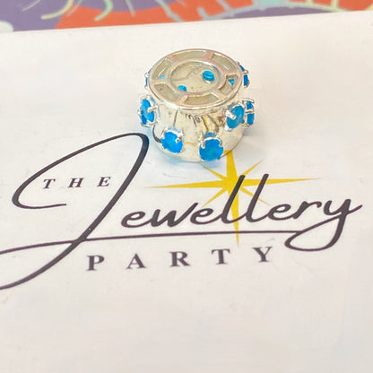 925 sterling silver charm with blue gemstones, featuring the hallmark maker's mark TGGC.