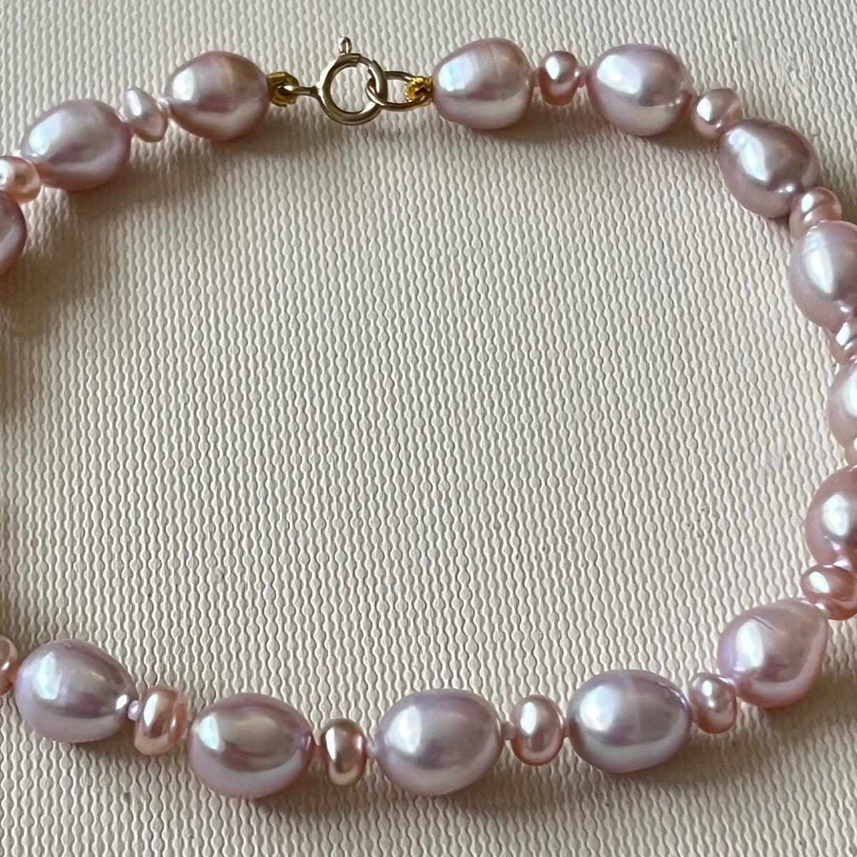Stunning Pink Cultured Freshwater Pearl Bracelet with a delicate 9ct gold clasps securing it perfectly.  Hallmarked 375 on the clasp presented in a beautiful wooden box